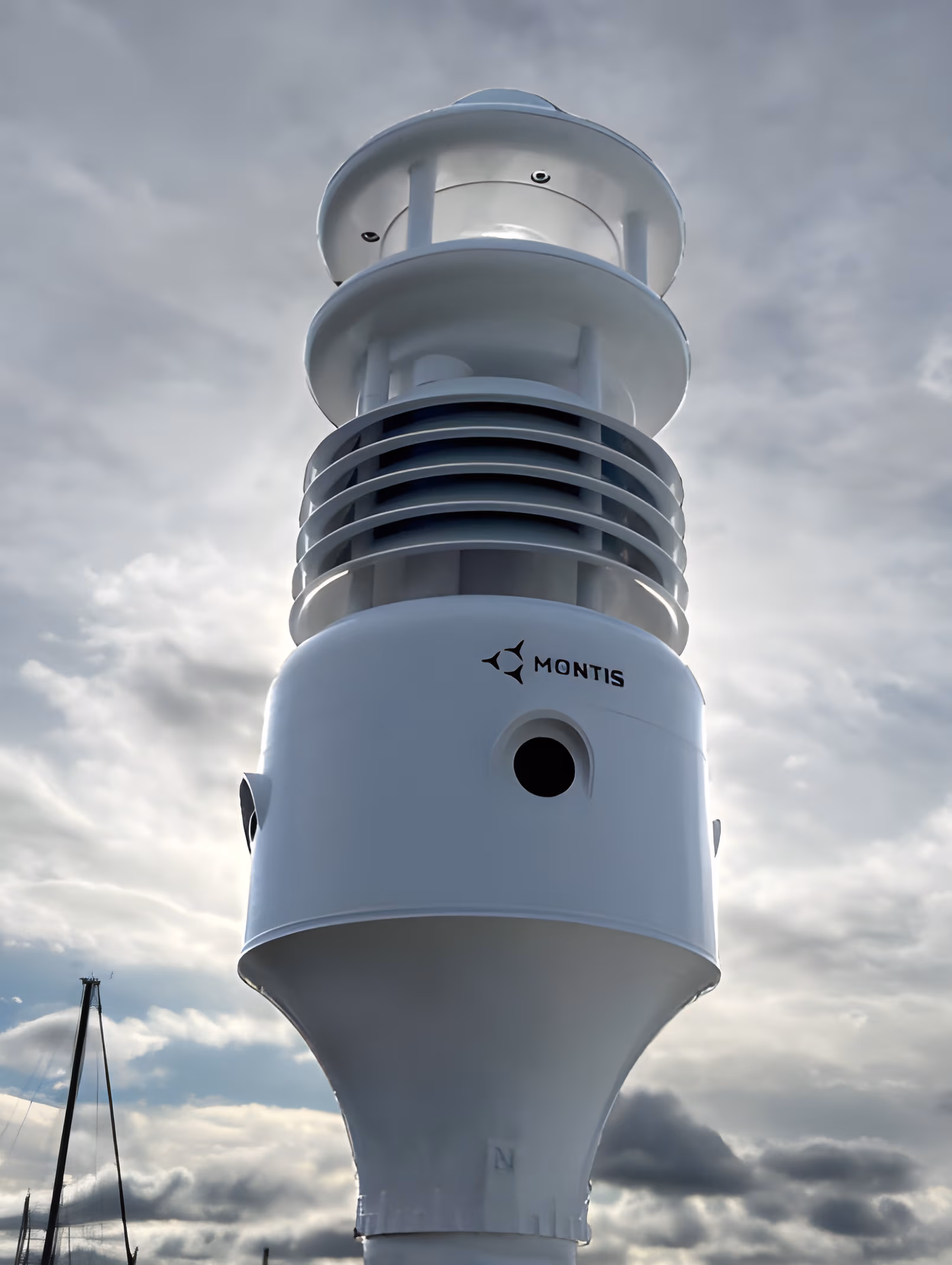 Montis MWOS weather observation unit mounted outdoors against a cloudy sky
